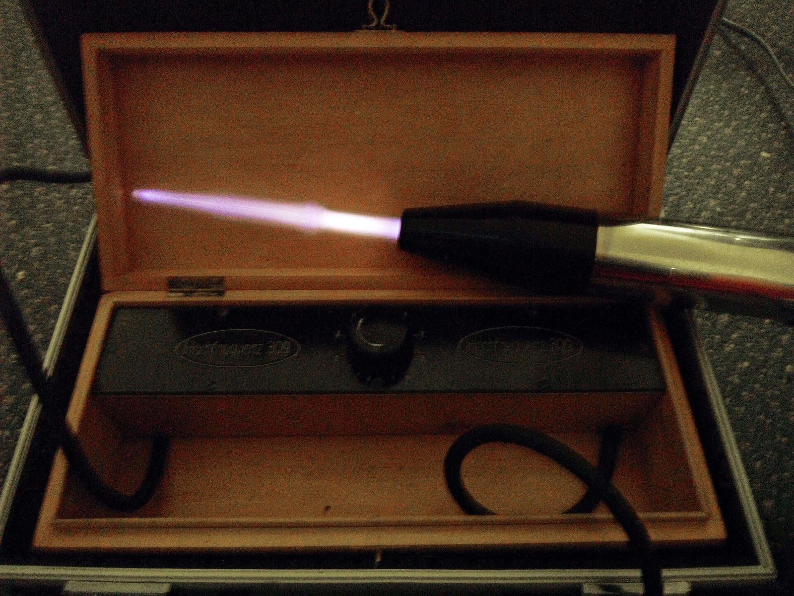 Figure 2 — The effect the whole industry was selling: a violet-ray electrode running, the rarefied gas inside the glass lit by high-frequency discharge. It glows, it crackles, it smells faintly of ozone, and …