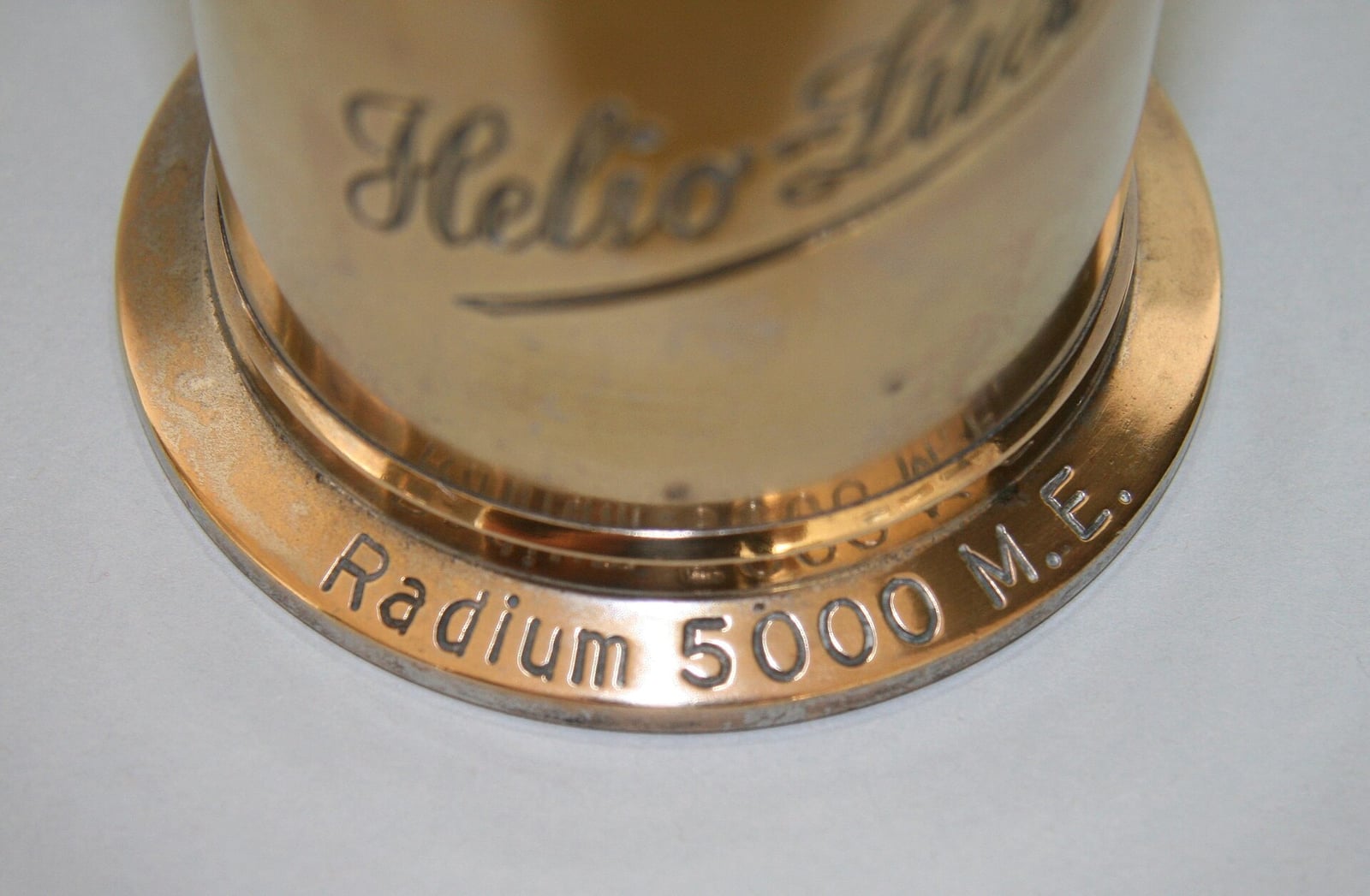 Figure 8 — The same emanator's base, stamped "Radium 5000 M.E." — Mache units, an actual radiological measure. Quackery of this generation borrowed the vocabulary of metrology wholesale; a number on a casting…