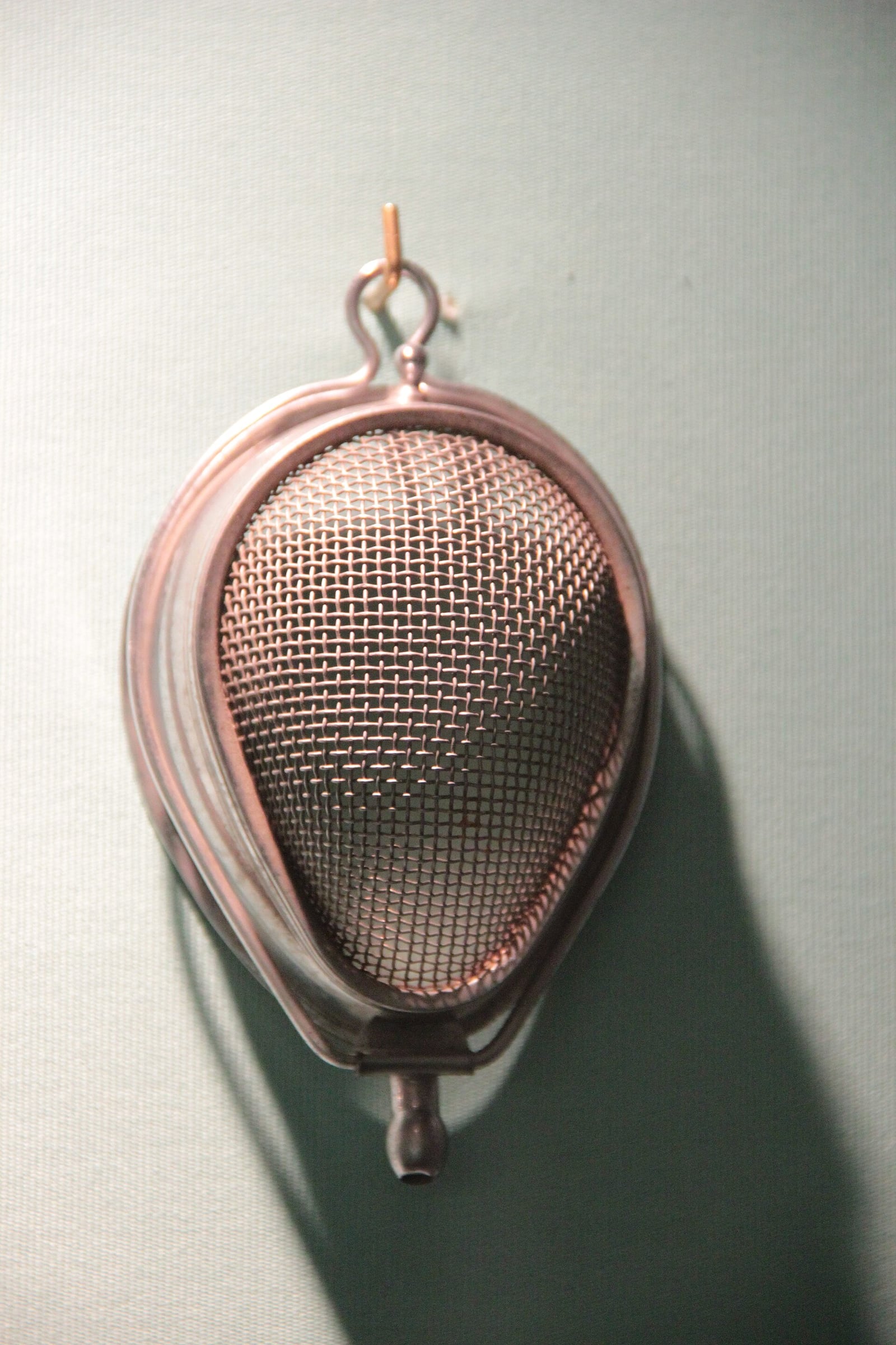 Figure 2 — A Yankauer mask: a kidney-shaped frame carrying a fine wire-mesh bed for the gauze, rimmed by a gutter to catch what ran off, with a wire bail to hold the pad down. This is the "face mask" the Sore…